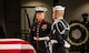 A Marine and a Sailor stand watch next to the flag-draped casket of former President Jimmy Carter.