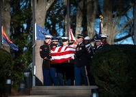 A team of services members from each branch of the armed forces is carrying the flag-draped casket of former President Jimmy Carter.