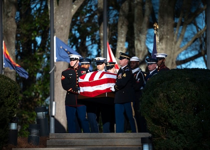 A team of services members from each branch of the armed forces is carrying the flag-draped casket of former President Jimmy Carter.