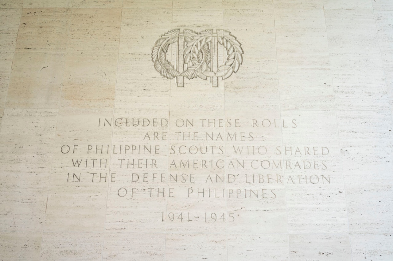 A white wall has inscription on it.
