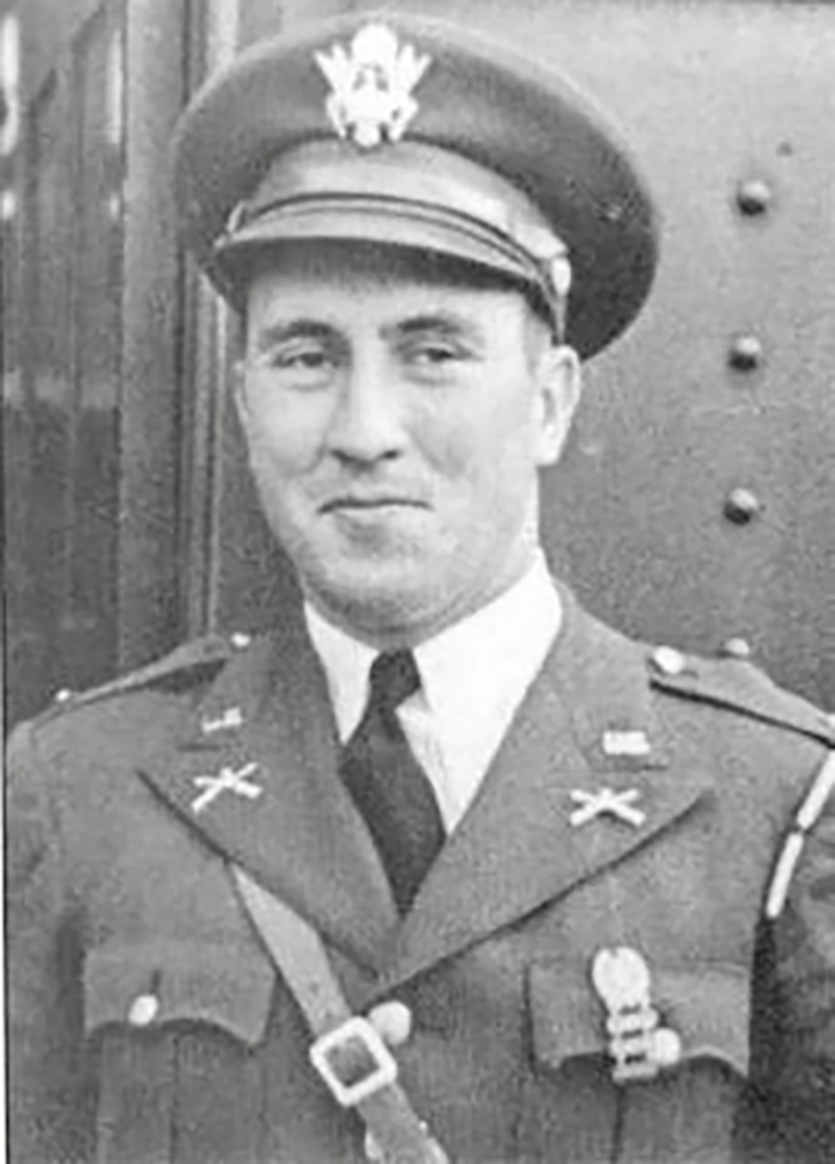 A man in a uniform and cap poses for a photo.