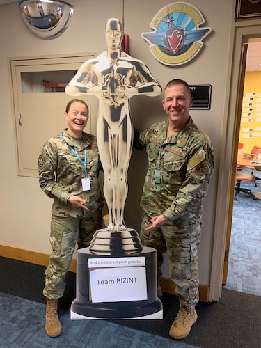 Image of people posing with award statue.