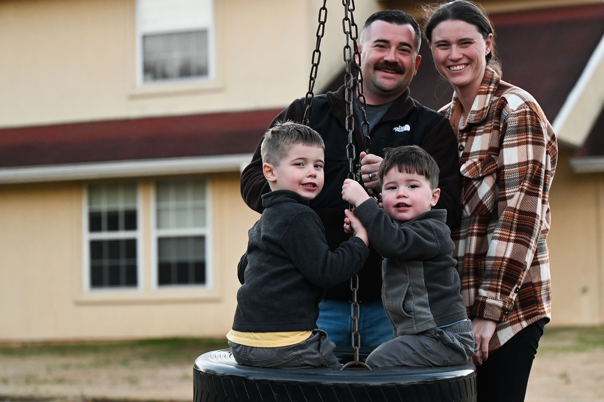 U.S. Air Force Master Sgt. Scott Brakefield, 42nd Security Forces Squadron kennel master, and his spouse, Tech. Sgt. Renna Brakefield, Headquarters Air Force, Air Force Judge Advocate General's School paralegal instructor, pose for a photograph with their two sons, Harrison, left, and Wesley, right, at Webster Park on Maxwell Air Force Base, Alabama, Jan. 3, 2024.