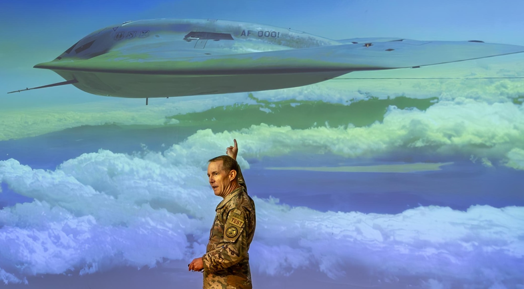 Brig. Gen. Doug Wickert, 412th Test Wing commander, points to an image of the B-21 Raider in flight during an Edwards-based test mission. “Today is not the day to start World War III, because we have this.”