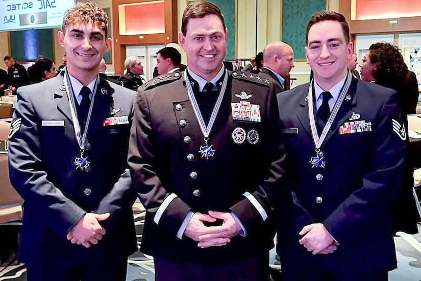 Three service members pose for a photo.