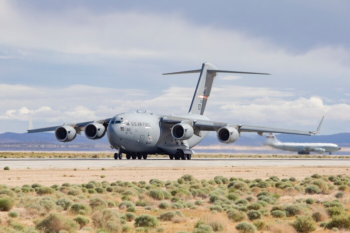 Edwards Air Force Base C-17 33121 of the 418th FLTS begins its takeoff roll from EDW as Edwards KC-135 10320 awaits its turn. Both aircraft play vital roles in the mission of the 412th Test Wing. (Air Force photo by Todd Schannuth)