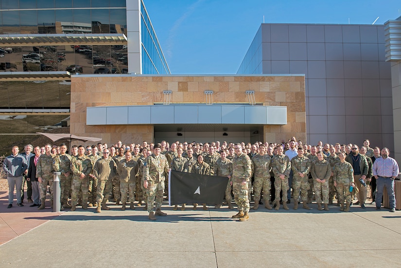 A large group of a guardians pose in front of a building.