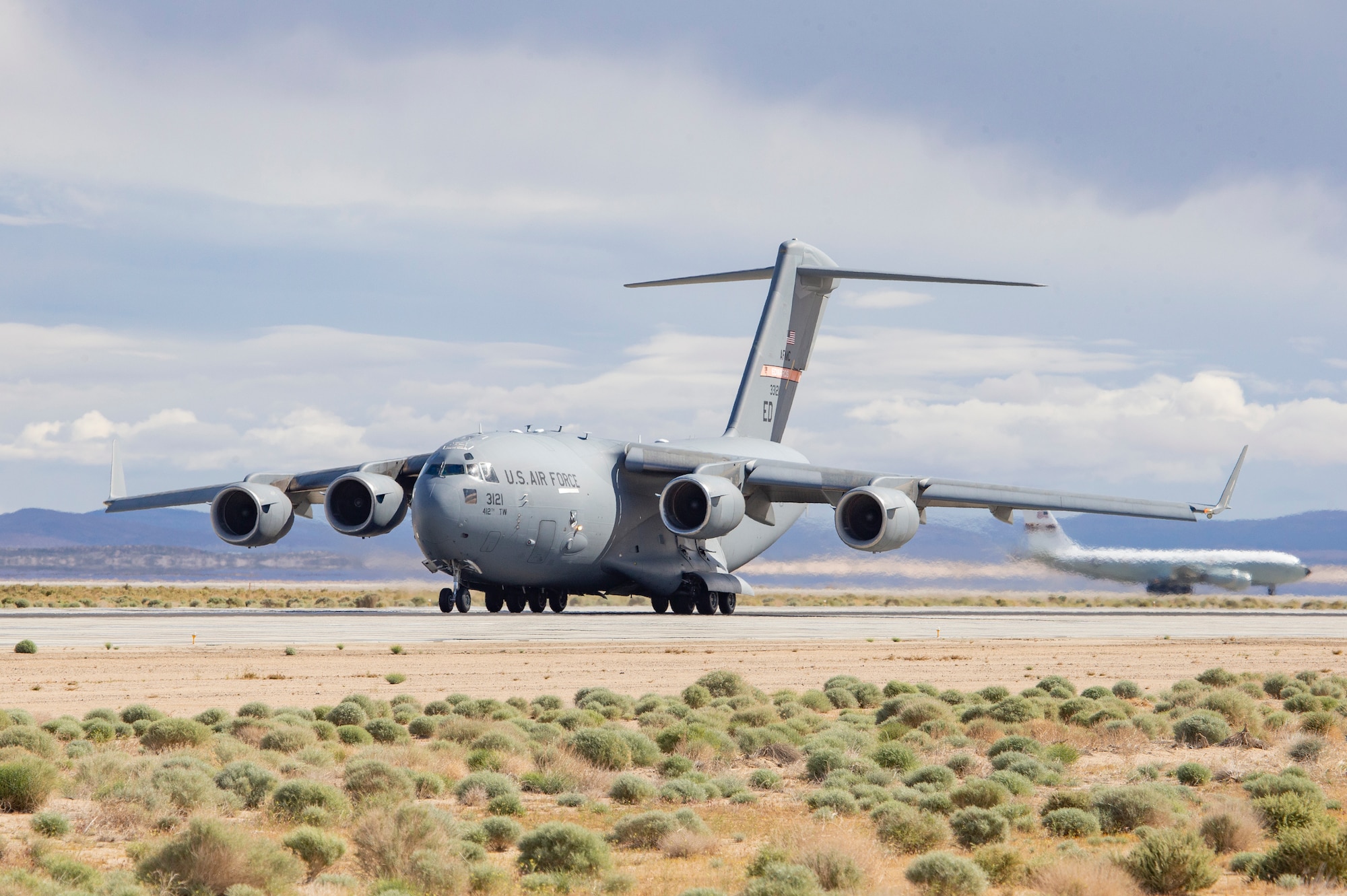 Edwards Air Force Base C-17 33121 of the 418th FLTS begins its takeoff roll from EDW as Edwards KC-135 10320 awaits its turn. Both aircraft play vital roles in the mission of the 412th Test Wing. (Air Force photo by Todd Schannuth)