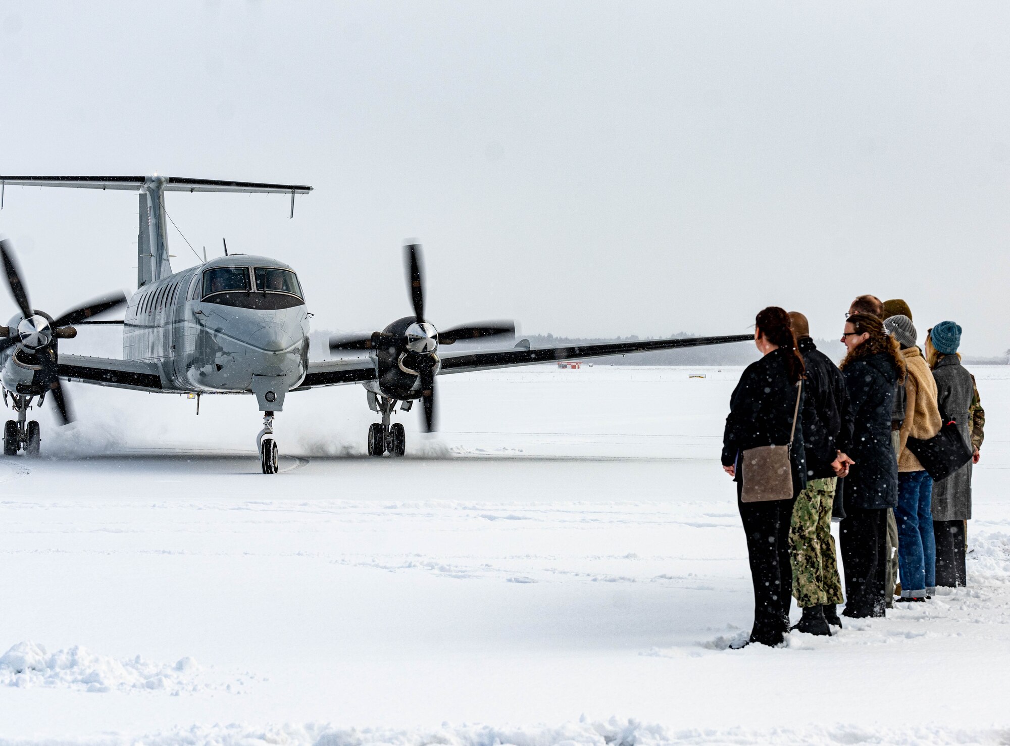 A welcome party awaits on a snowy runway for the arrival of U.S. Air Force Lt. Gen. Stephen Jost, U.S. Forces Japan and 5th Air Force commander, at Misawa Air Base, Japan, Dec. 16, 2024. Jost visited the installation to engage with leaders and members of the community to assess operational capabilities and infrastructure, ensuring informed decision-making on projects pertaining to mission readiness, quality of life and bilateral alliance. (U.S. Air Force photo by Staff Sgt. Kelsea Caballero)