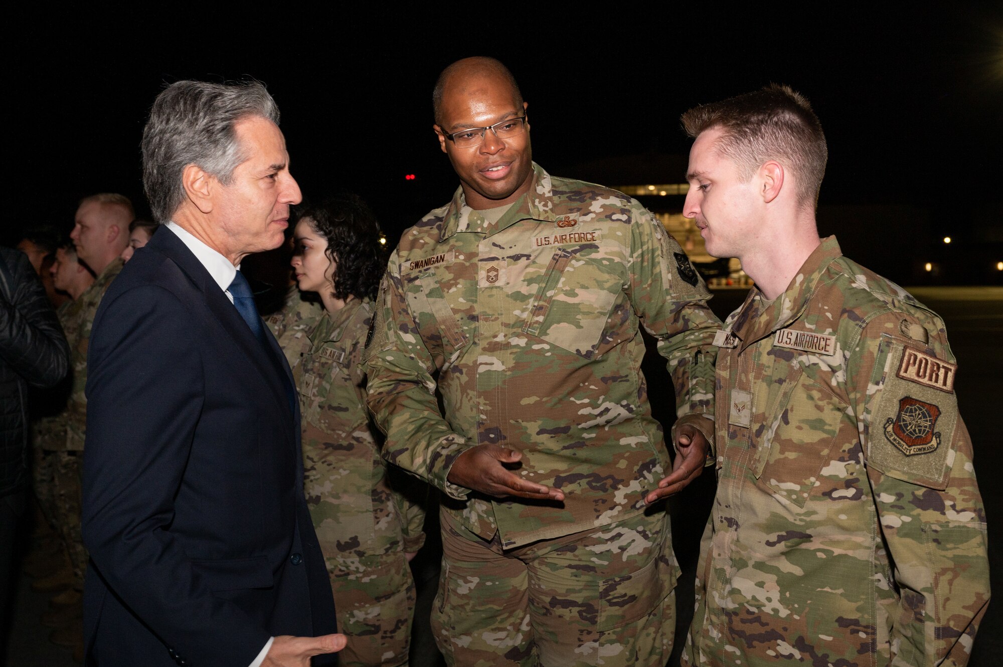 Secretary of State Antony Blinken prepares to coin Airman 1st Class Joshua Massey, 730th Air Mobility Squadron special handling technician, at Yokota Air Base, Japan.