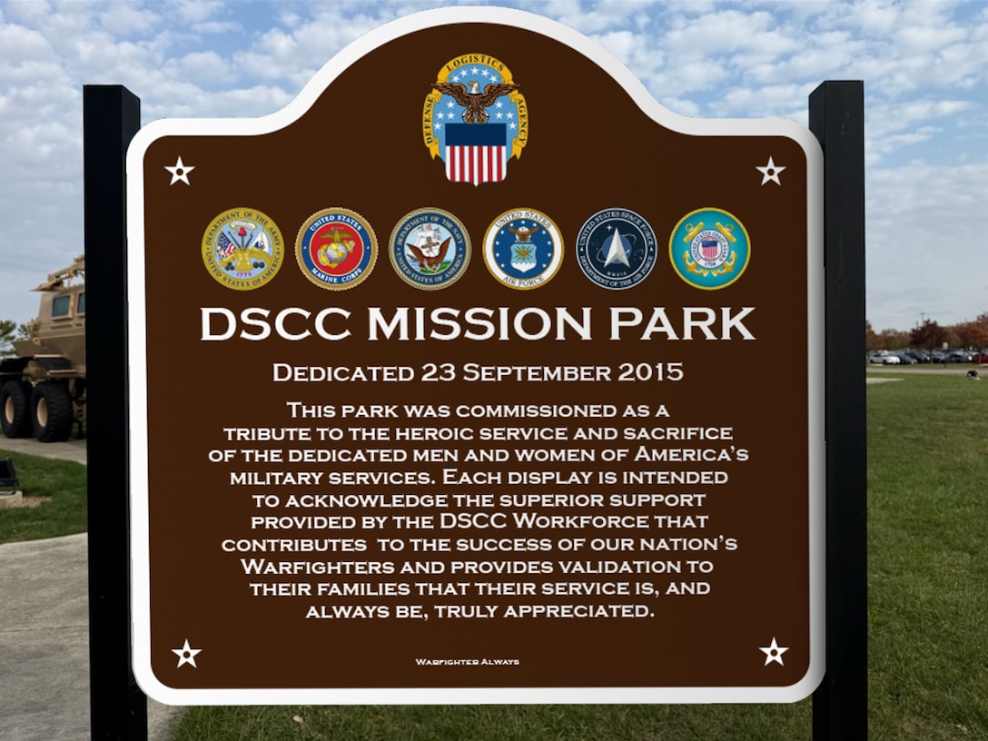 Brown sign with DLA and military logos at top. Under that reads: DSCC Mission Park - followed by a paragraph