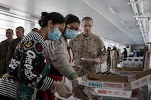 Volunteers with Marine Corps Community Services, Marine Corps Recruit Depot San Diego, pass out pizza and snacks to Marines and recruits with Special Training Company for operation happy holiday at MCRD San Diego, California, Dec. 16, 2024. MCCS hosted operation happy holiday to spread holiday cheer to recruits and Marines who will be away from family for the holiday season. (U.S. Marine Corps photo by Cpl. Sarah M. Grawcock)