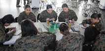 U.S. Marines and recruits with Special Training Company make holiday cards for operation happy holiday at MCRD San Diego, California, Dec. 16, 2024. The Mascot’s job is to boost morale, participate in outreach work and attend events and ceremonies.  Marine Corps Community Services, MCRD San Diego, hosted operation happy holiday to spread holiday cheer to recruits and Marines who will be away from family for the holiday season. (U.S. Marine Corps photo by Cpl. Sarah M. Grawcock)