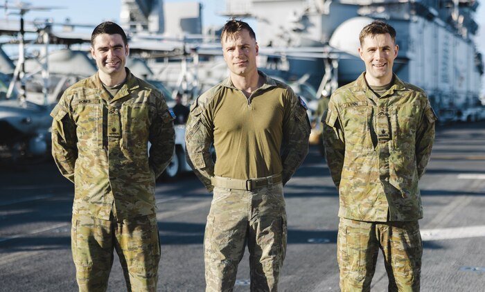 From left to right, Australian Army Maj. Jack Jones, the assistant logistics officer assigned to the 15th Marine Expeditionary Unit; Maj. Rhys Davies, an AH-1Z Viper pilot assigned to Marine Medium Tiltrotor Squadron (VMM) 165 (Reinforced), 15th MEU; and Maj. George Lynn, the assistant operations officer assigned to the 15th MEU, pose for a photo aboard the amphibious assault ship USS Boxer (LHD 4) while underway in the Pacific Ocean Nov. 21, 2024. Jones, Davies, and Lynn served as foreign exchange officers with the 15th MEU through the Marine Corps Personnel Exchange Program, and recently completed a deployment with the 15th MEU to the Indo-Pacific region. (U.S. Marine Corps photo by Cpl. Luis Agostini)