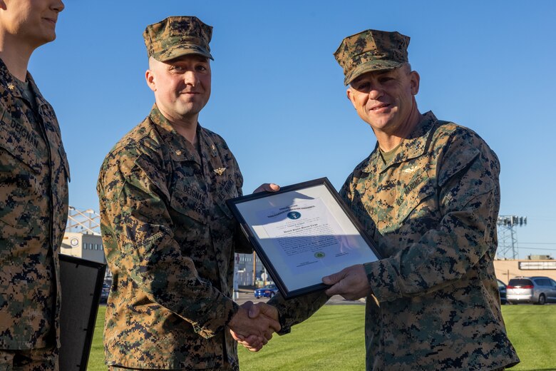 U.S. Marine Corps Maj. Gen. James B. Wellons, right the commanding general of 3rd Marine Aircraft Wing, and Maj. Connor Deignan, center, a CH-53E Super Stallion helicopter pilot with Marine Heavy Helicopter Squadron (HMH) 361, Marine Aircraft Group 16, 3rd MAW, pose for a photo  during a promotion ceremony at Marine Corps Air Station Miramar, California, Jan. 6, 2025.