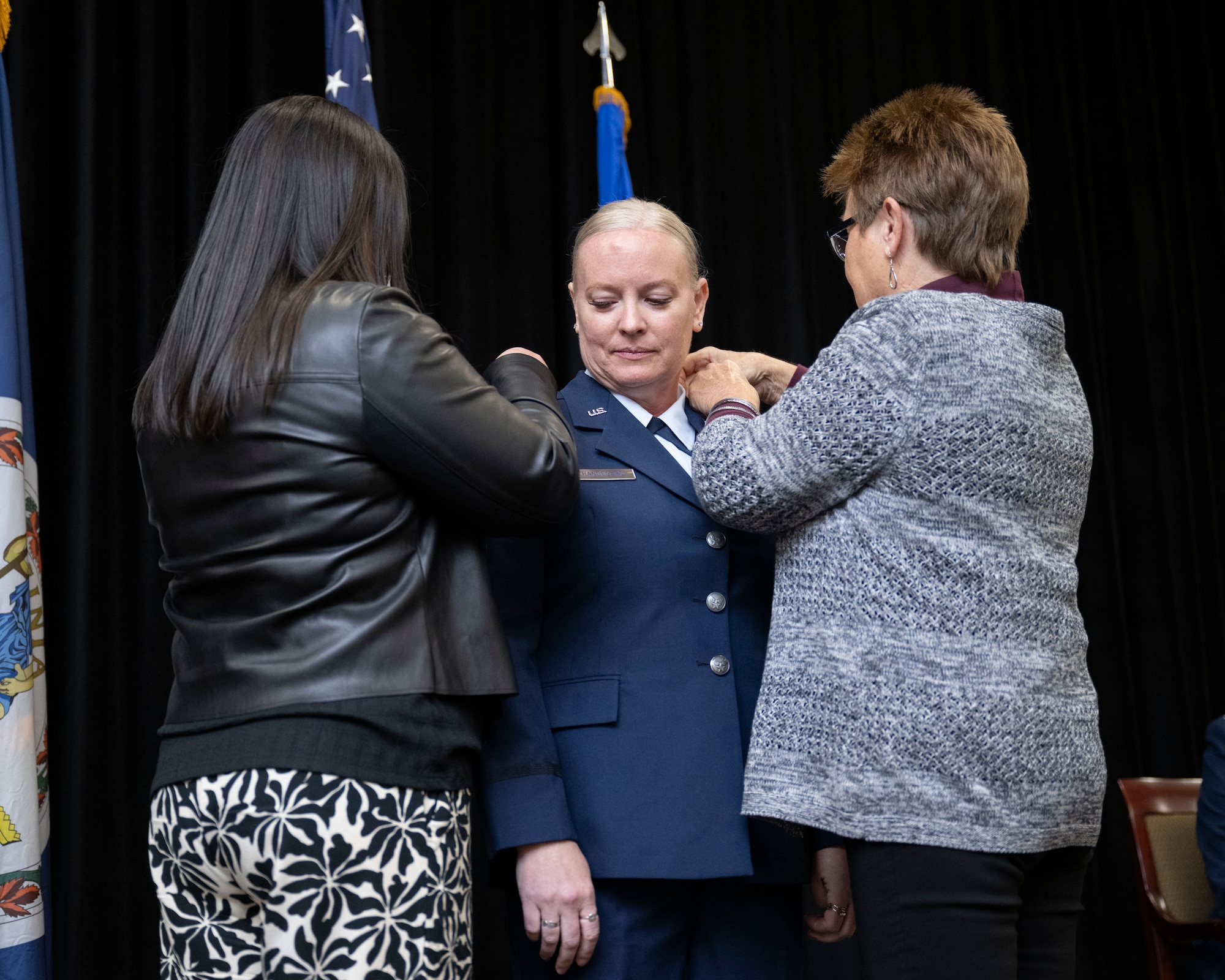 Lt. Col. Sarah E. Handegard, center, with her mom and sister pinning on her new rank.