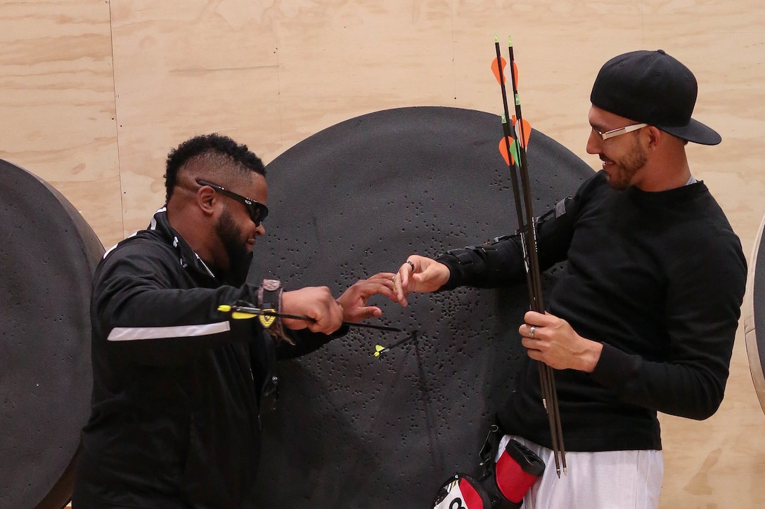 U.S Army Veteran, Staff Sgt. Bobby Green, of San Antonio, Texas, and U.S. Army Veteran, Sgt.  Robbie Gaupp, of Gatesville, Texas, remove the arrows from Gaupp's target during archery training for the Department of Defense Warrior Games