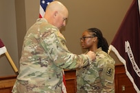Retired Col. Jim McDermott from the Army Joint Modernization Command pins the Purple Heart on Sgt Aneska Holness on Dec 4, 2024, at Fort Bliss, Texas.