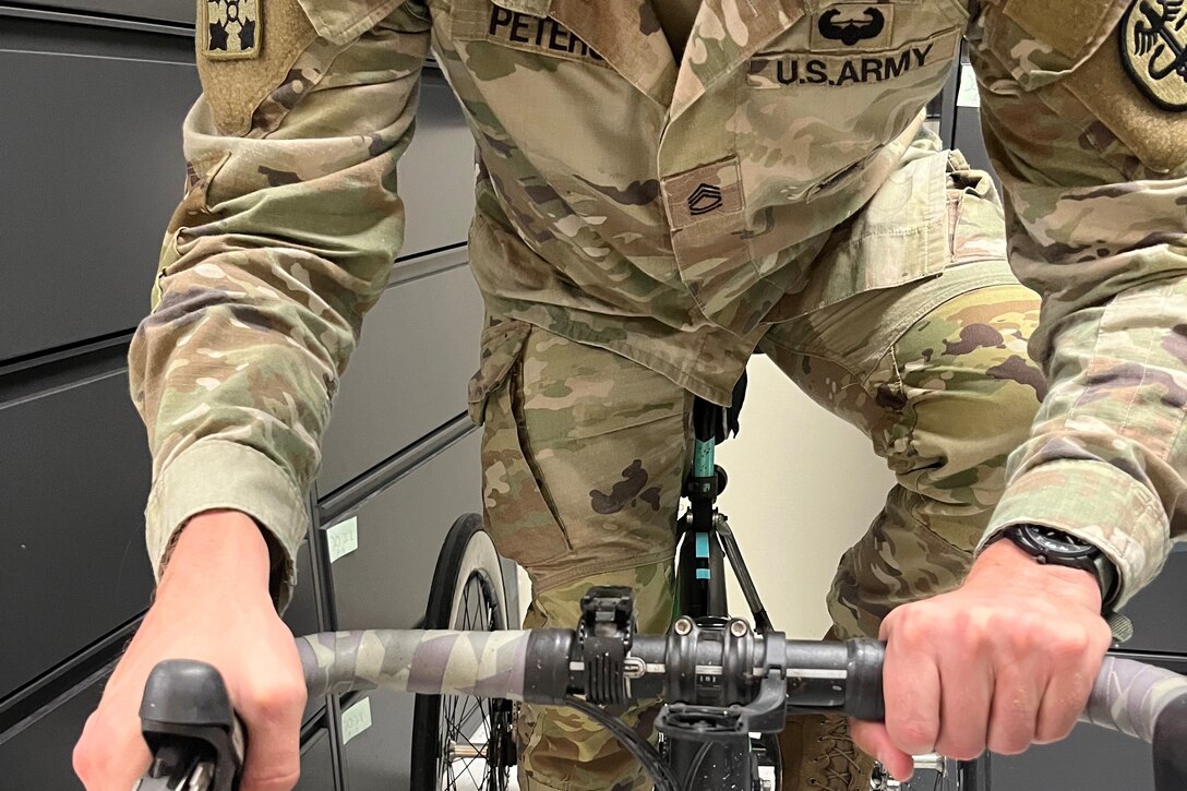 Sgt. 1st Class Jeffrey Peters demonstrates the “ataxi-grip” on the upright tricycle he uses for competition. November 6, 2024.