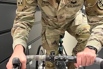 Sgt. 1st Class Jeffrey Peters demonstrates the “ataxi-grip” on the upright tricycle he uses for competition. November 6, 2024.