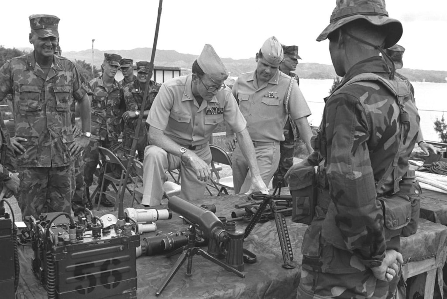 Vice Admiral James R. Hogg, commander, 7th Fleet, inspects various types of equipment used by the Marine Corps, including an M-60 machine gun, radios, and several kinds of sighting gear -