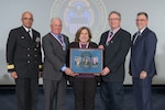Four men and one women pose for a photo during a Hall of Fame ceremony honoring new inductees.