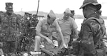 Vice Admiral James R. Hogg, commander, 7th Fleet, inspects various types of equipment used by the Marine Corps, including an M-60 machine gun, radios, and several kinds of sighting gear.