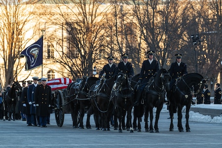 A ceremonial Honor Guard Joint Service Casket Team leads Former President Jimmy Carter on a caisson during the procession service at the U.S. Navy Memorial Plaza, Washington, D.C.