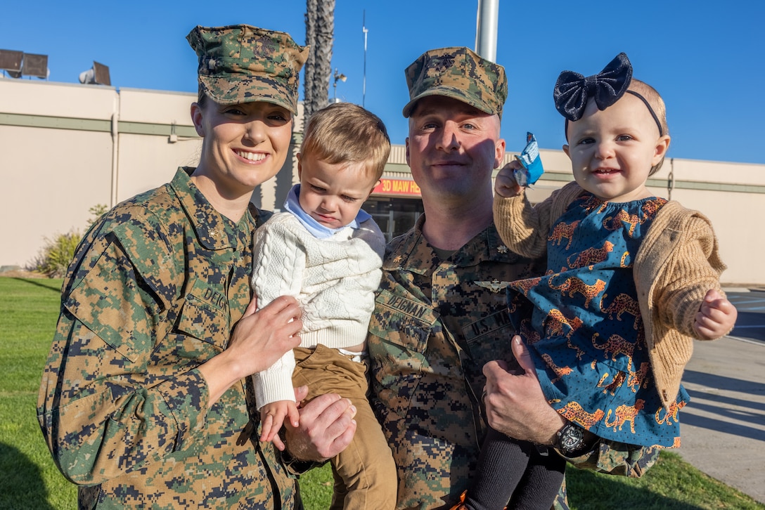 U.S. Marine Corps Maj. Leah Deignan, left,  an aviation maintenance officer with Aviation Logistics Division, Marine Wing Headquarters Squadron 3, 3rd Marine Aircraft Wing, and Maj. Connor Deignan, CH-53E Super Stallion helicopter pilot with Marine Heavy Helicopter Squadron (HMH) 361, Marine Aircraft Group 16, 3rd MAW, pose for a photo with their children after  a ceremony promoting the two to the rank of major at Marine Corps Air Station Miramar, California, Jan. 6, 2025.