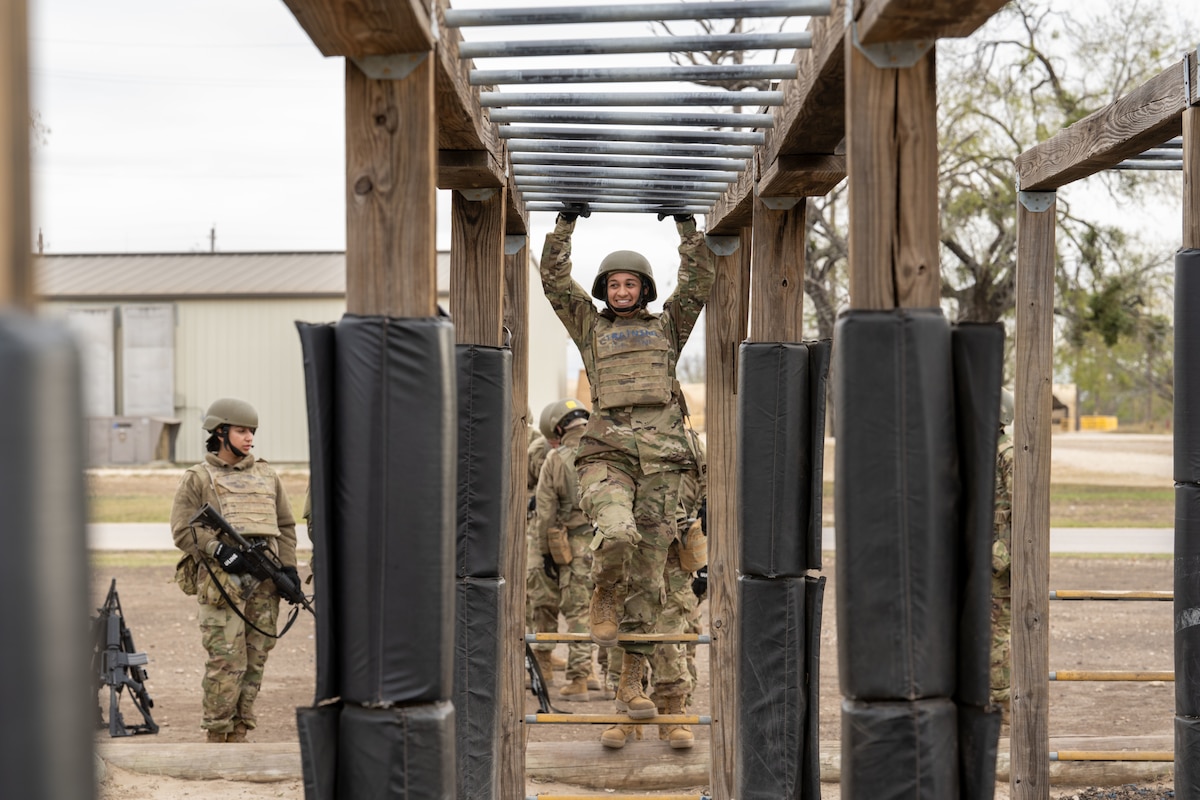 Trainee Anita Alvarez, 331st Training Squadron, hangs from the bars during the Confidence Course at PACER FORGE
