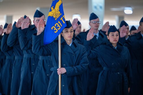 Airman Anita Alvarez raises her right hand to recite the Oath of Enlistment