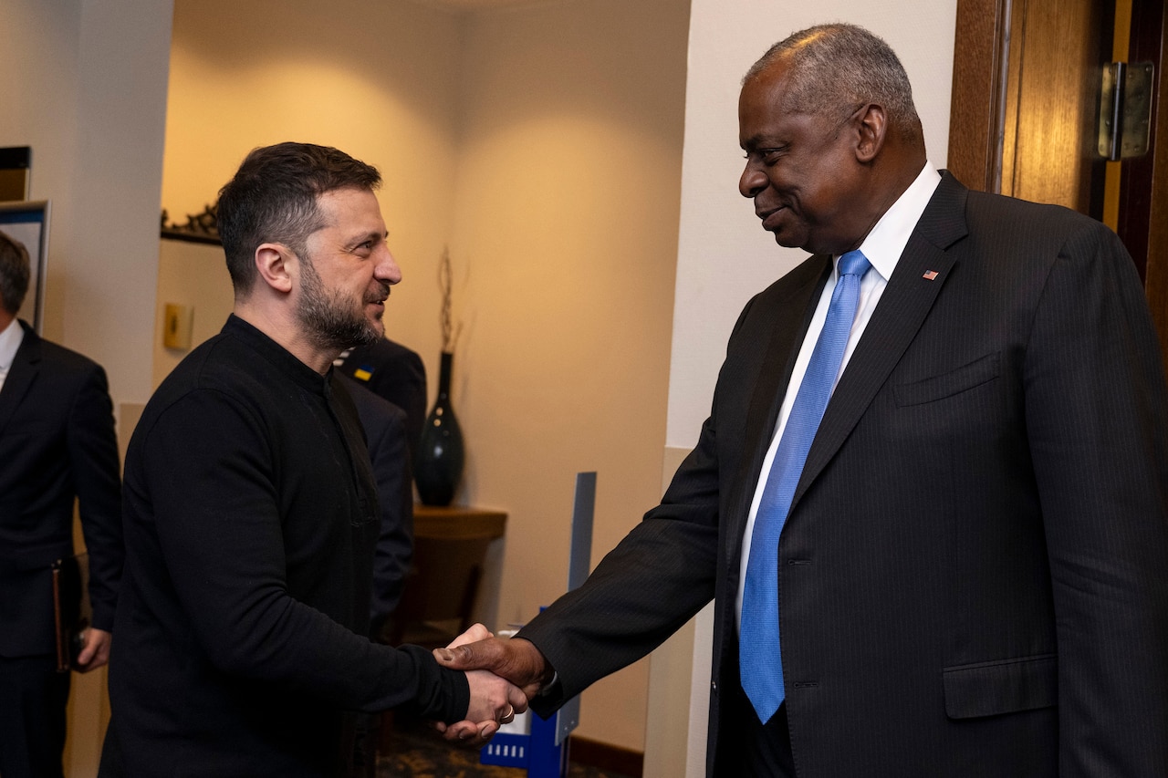Two civilians shake hands.
