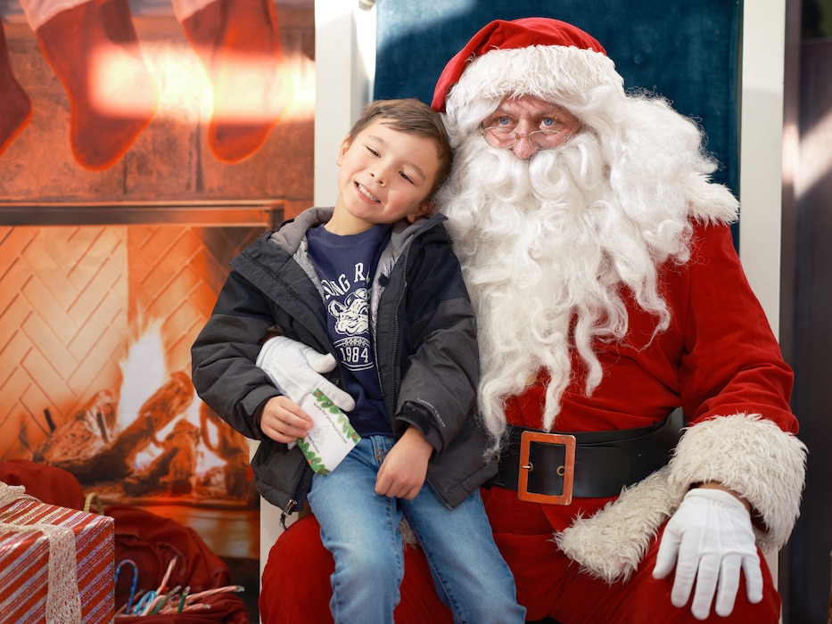 Santa Claus sits with a child for photos at the Commander, Fleet Activities Yokosuka (CFAY) Morale, Welfare and Recreation's (MWR) annual Festival of Trees Sunday, December 15 in the CFAY Headquarters Building C-2.