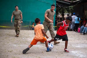 (Left) U.S. Army Sgt. Enoch Goncalez and (right) Spc. Jaden King, Joint Task Force-Bravo 349th Medical Detachment medics, play soccer with local children after a Medical Readiness Training Exercise in Choluteca, Honduras, January 8, 2025.
