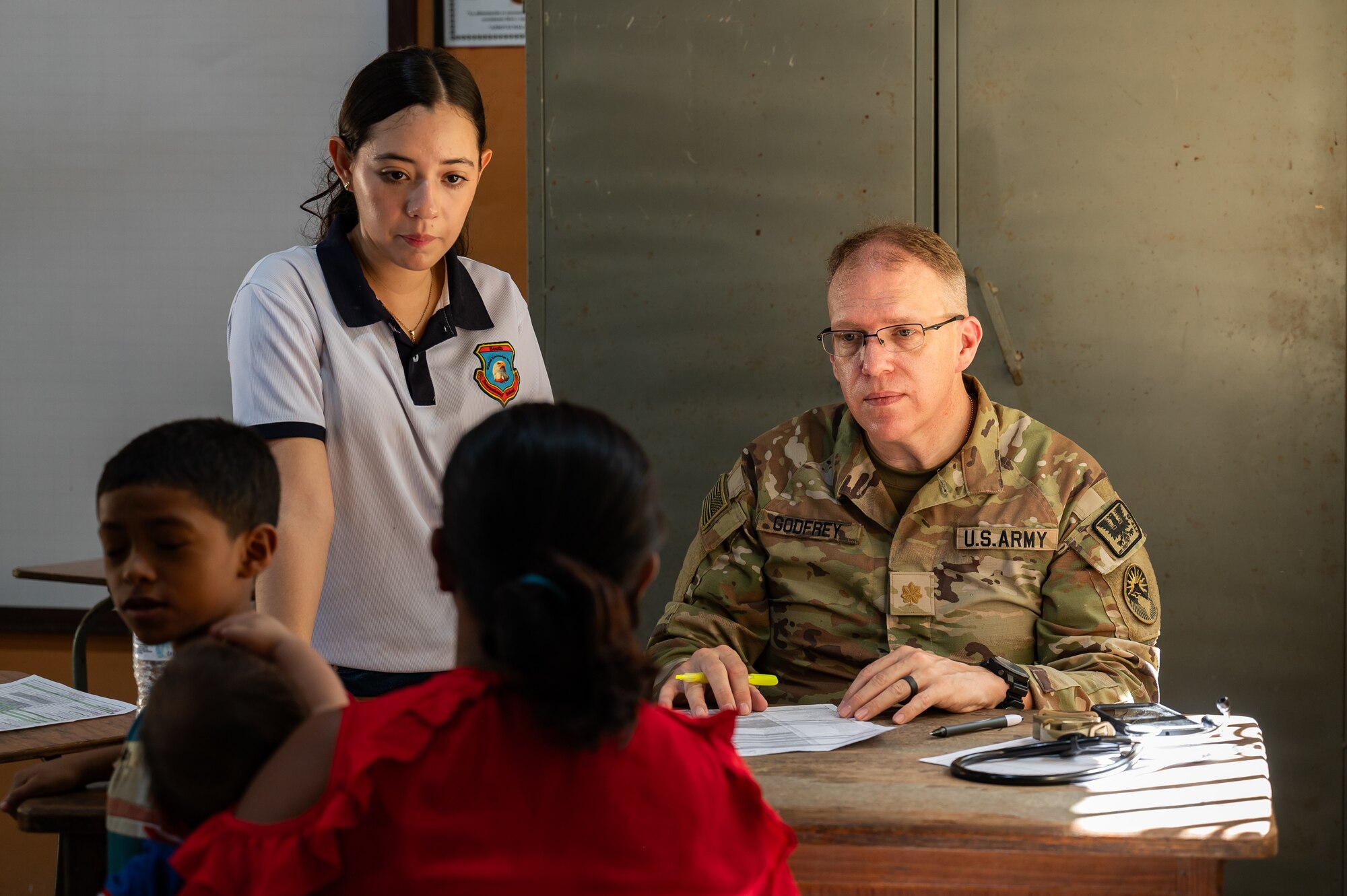 U.S. Army Maj Benjamin Godfrey, Joint Task Force-Bravo 349th Medical Detachment medical provider, speaks with patients during a Medical Readiness Training Exercise in Choluteca, Honduras, January 8, 2025.