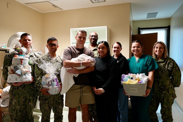 USNMRTC Sigonella/U.S. Naval Hospital Sigonella Triad and care team present family with donated gifts.