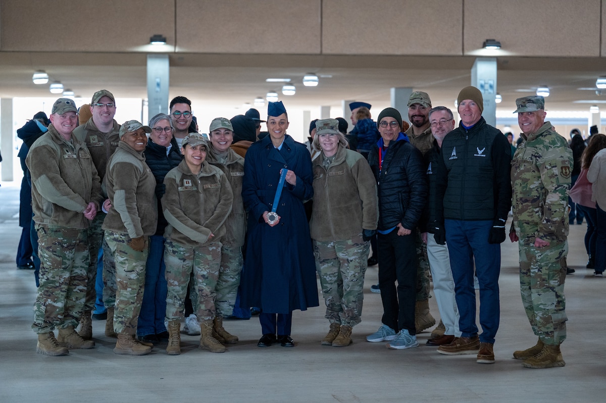 Airman Anita Alvarez smiles with her family and the leaders of Air Force Services Center and Department of the Air Force World Class Athlete Program