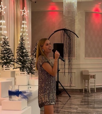 Beth Archer sang "All I Want For Christmas" at the USNMRTC Sigonella Holiday Party