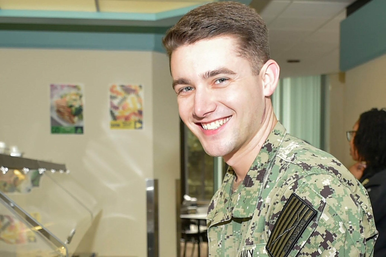 A man in a military uniform smiles for a photo.