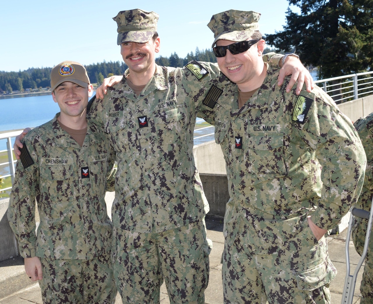 Three men in uniforms put their arms over each other's shoulders for a photo.