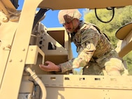A California National Guard Soldier conduct preventative maintenance checks on a M-ATV Mine Resistant Ambush Protected vehicle.