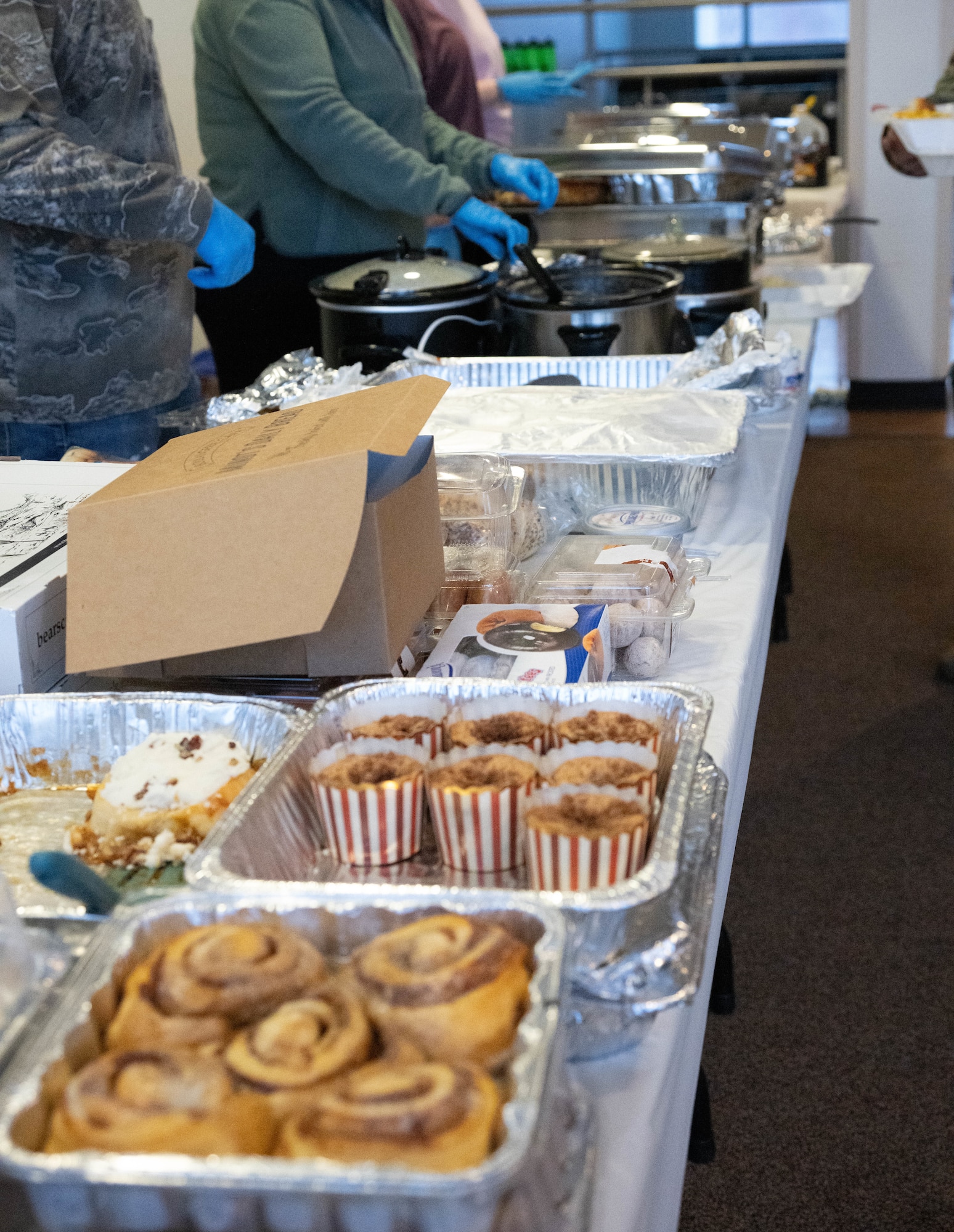 The Minot Spouses Club set up and provide food at a dorm dinner for Airmen at Minot Air Force Base, North Dakota, Jan. 8, 2025. The dorm dinner is an event put on by the Chaplain Corps and is facilitated by volunteer organizations and clubs every month for Airmen living in the dorms. (U.S. Air Force photo by Airman 1st Class Wesley Davies)
