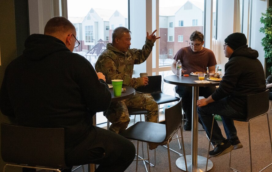 Airmen talk and eat with chaplains at the dorm dinner facilitated by the Minot Spouses Club at Minot Air Force Base, North Dakota, Jan. 8, 2025. The dorm dinner is hosted once every month and provides Airmen with an opportunity to build community and get a free dinner. (U.S. Air Force photo by Airman 1st Class Wesley Davies)