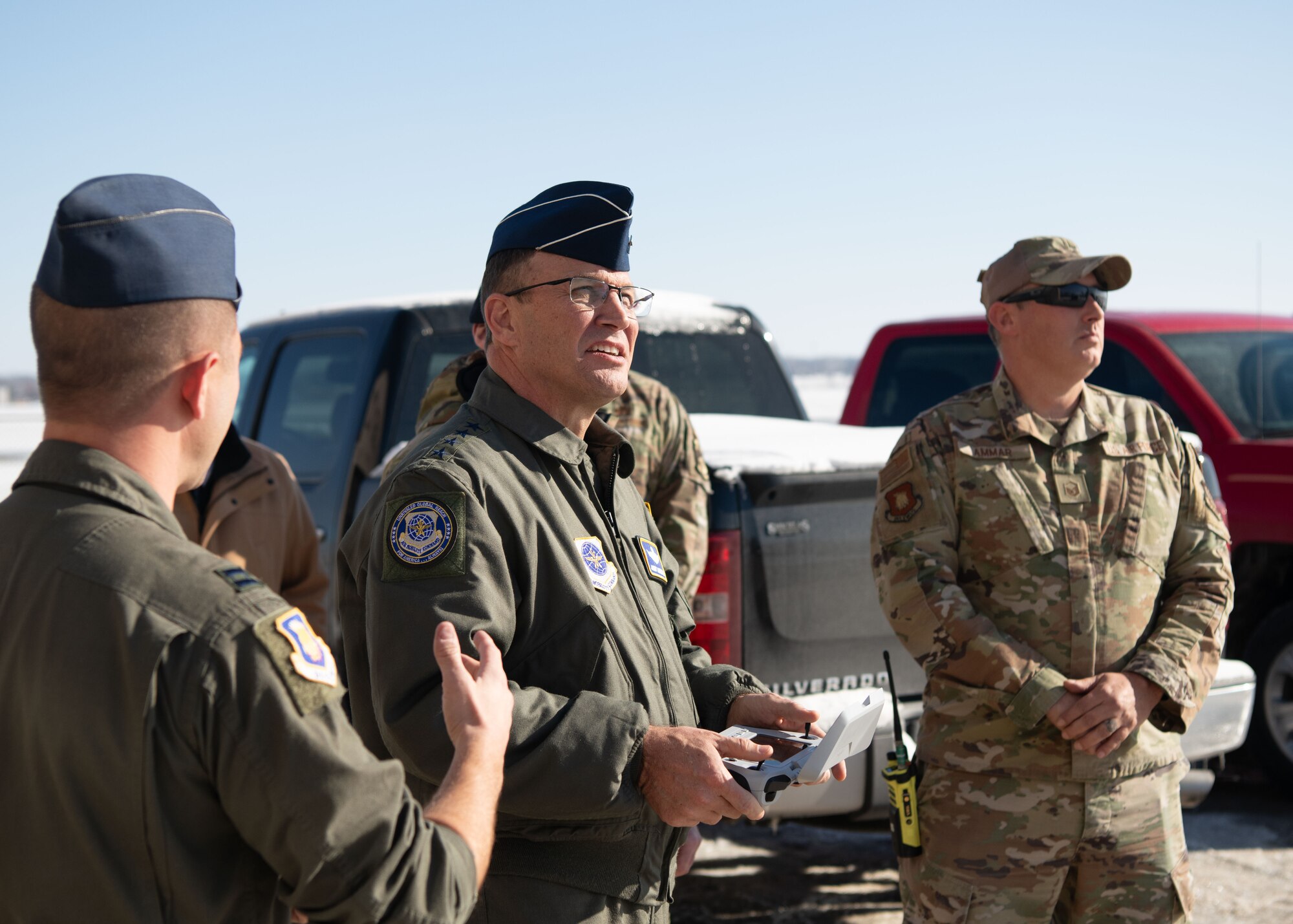 A man in a military uniform holds a drone controller.