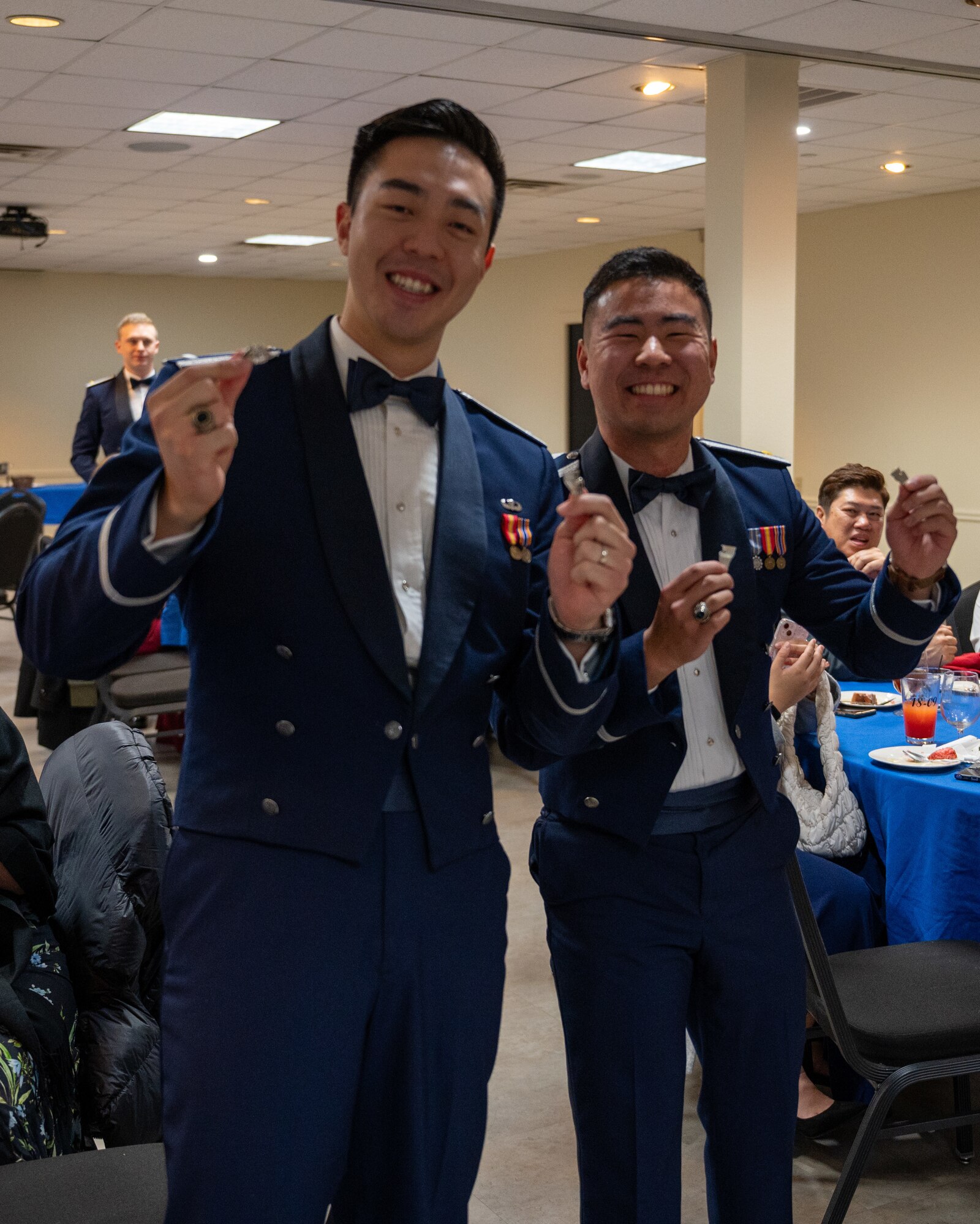 Newly graduated U.S. Air Force pilots present the broken wings to the camera at Laughlin Air Force Base, Texas, Jan. 9, 2025.  The breaking of the wings is a tradition that goes back to the origin of flight, where the first pair of wings given to them are never to be worn, instead they are broken in half with one have given to a loved one for luck. (U.S. Air Force photo by Staff Sgt. Nicholas Larsen)