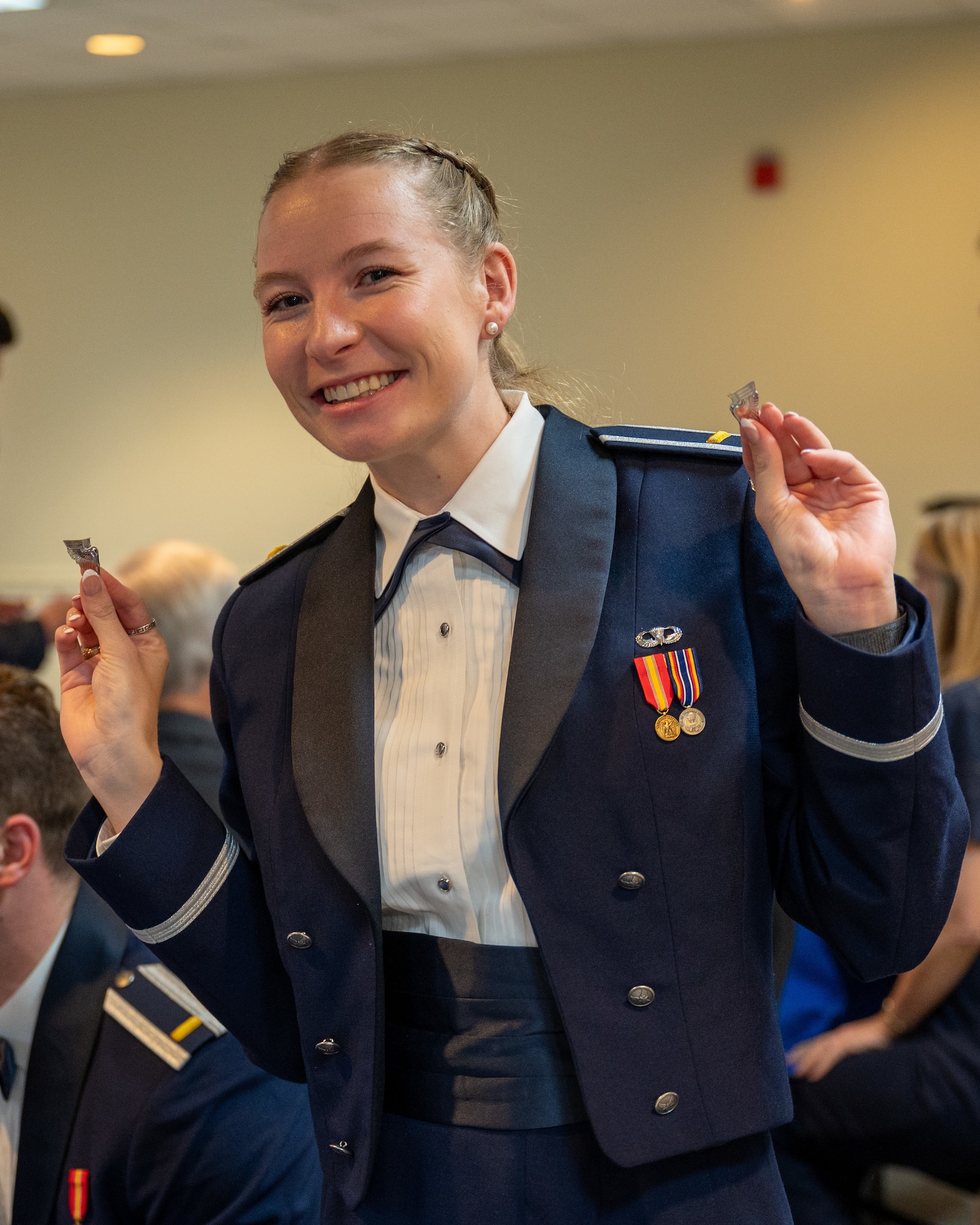 A newly graduated U.S. Air Force pilot presents the broken wings to the camera at Laughlin Air Force Base, Texas, Jan. 9, 2025.  The breaking of the wings is a tradition that goes back to the origin of flight, where the first pair of wings given to them are never to be worn, instead they are broken in half with one have given to a loved one for luck. (U.S. Air Force photo by Staff Sgt. Nicholas Larsen)