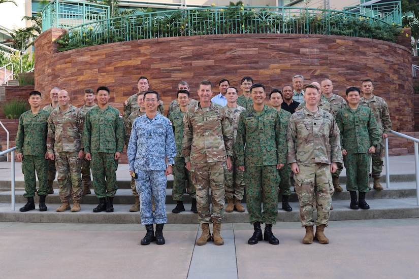 A group of military leaders pose in front of a building.