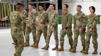 Photo of a U.S. Space Force Guardians practicing marching movements inside a military hangar.