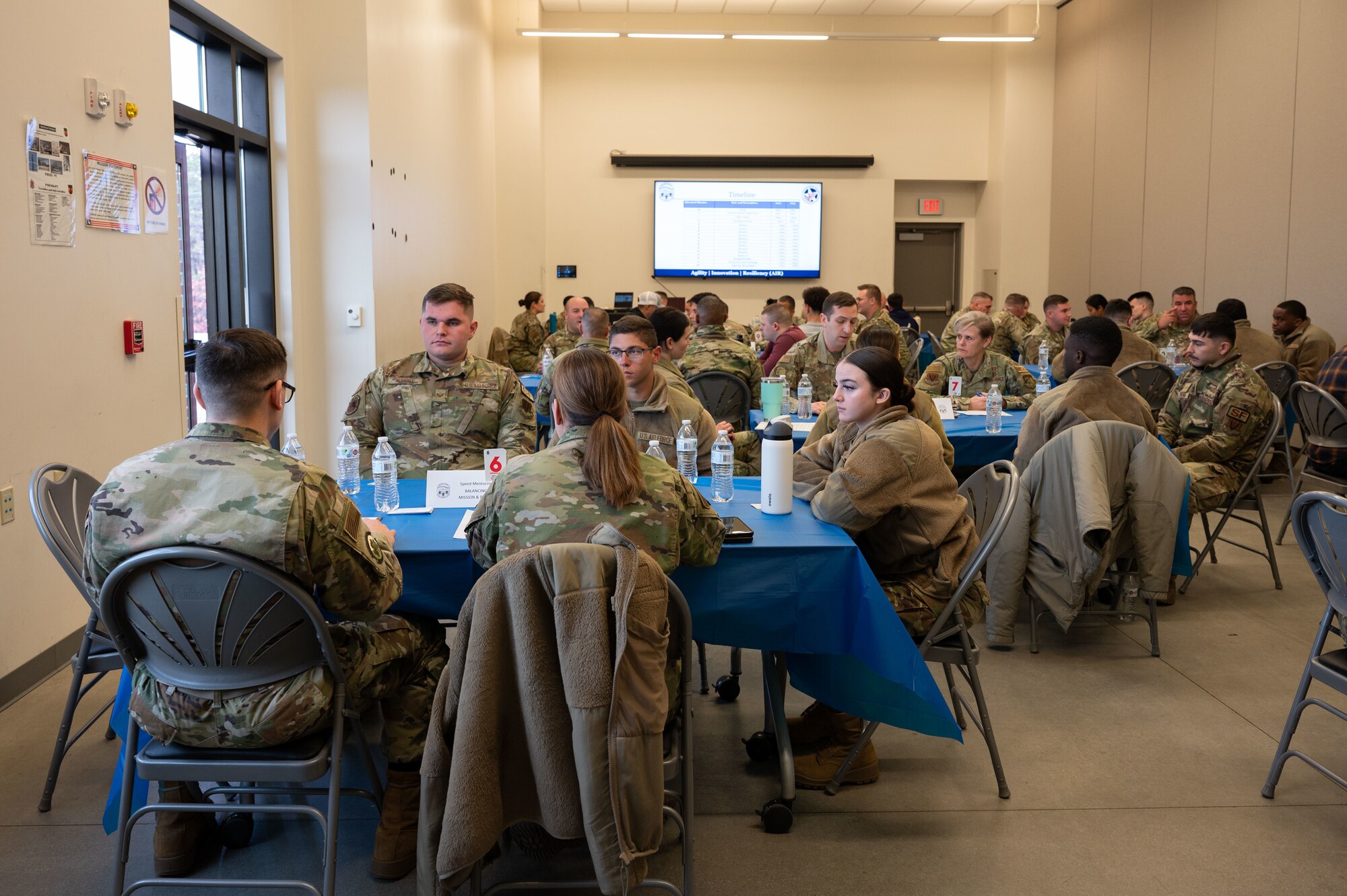 Airmen sit around a table during the speed mentoring event.