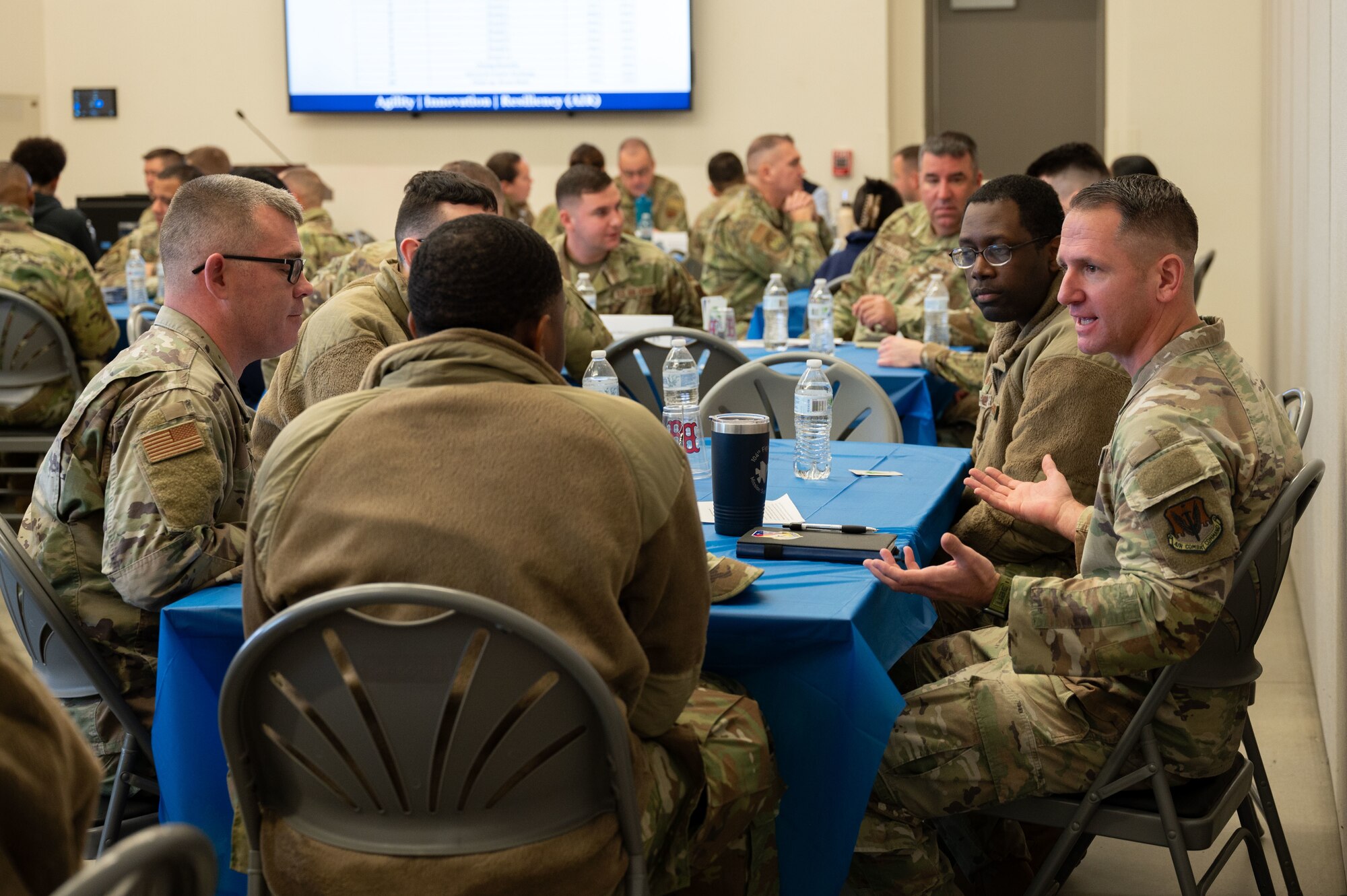 Airmen sit around a table during the speed mentoring event.